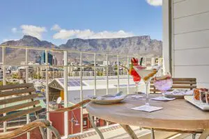 Enjoy an afternoon tipple with a view from the balcony of a Junior Mountain Suite at Queen Victoria Hotel.