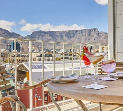 Enjoy an afternoon tipple with a view from the balcony of a Junior Mountain Suite at Queen Victoria Hotel.