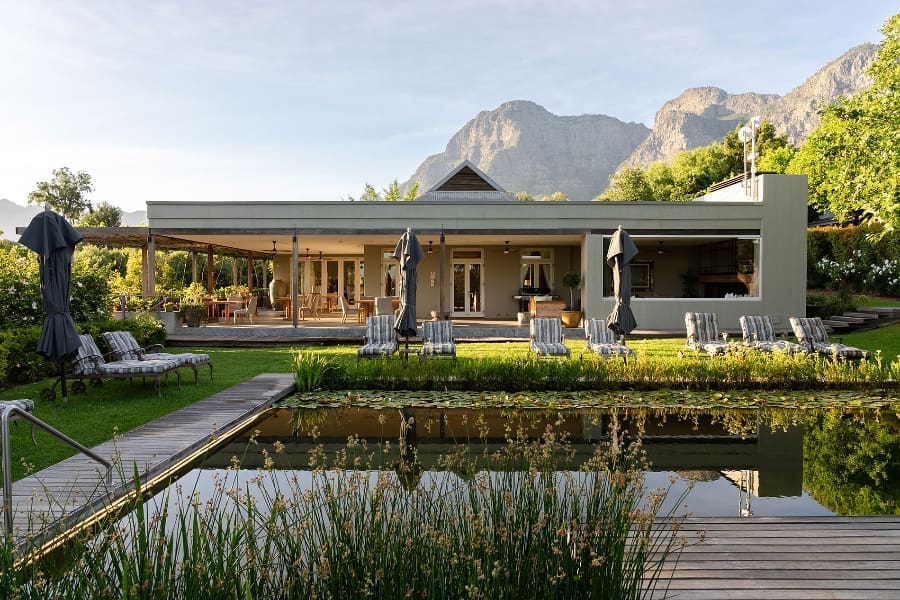 Mirando a través de una piscina hacia el Hotel Angala en Franschhoek y las montañas más allá | Go2Africa