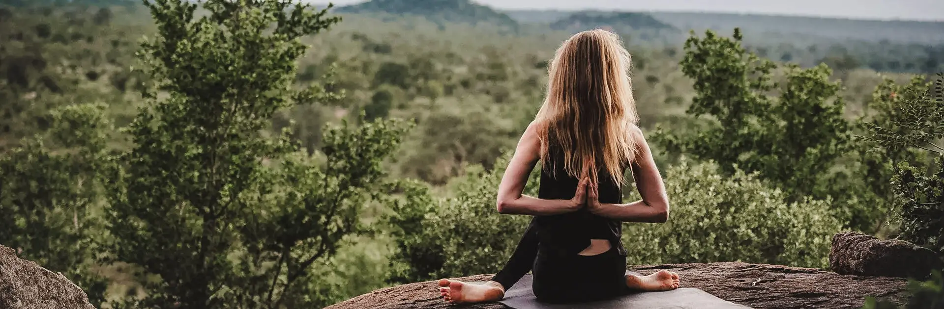 Yoga matutino en Londolozi: una mujer contempla la selva circundante desde una posición elevada | Go2Africa