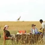 Desayuno en la sabana con jirafas al fondo en el campamento de Olakira.