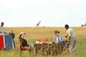 Desayuno en la sabana con jirafas al fondo en el campamento de Olakira.