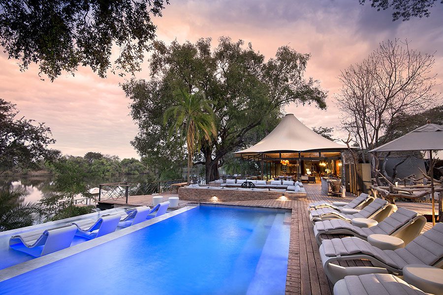 A long pool with loungers looking over the river beyond at Thorntree River Lodge | Go2Africa
