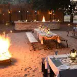 Disfrute de suntuosas comidas junto al fuego en el Boma, un punto culminante del safari. 