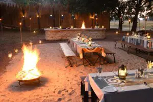 Disfrute de suntuosas comidas junto al fuego en el Boma, un punto culminante del safari. 