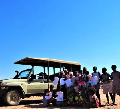 People standing in front of a safari vehicle in Namibia.