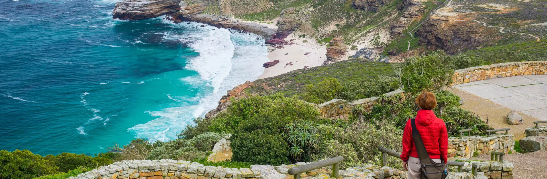 Un excursionista bajando a la playa del cabo disfrutando de Travelife