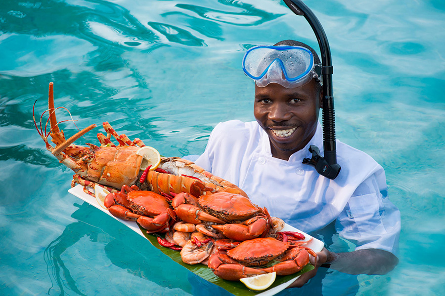 Fresh seafood served by a waiter in an ocean in Mozambique.