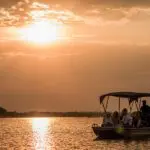 Crucero fluvial al atardecer en el Tongabezi Lodge.