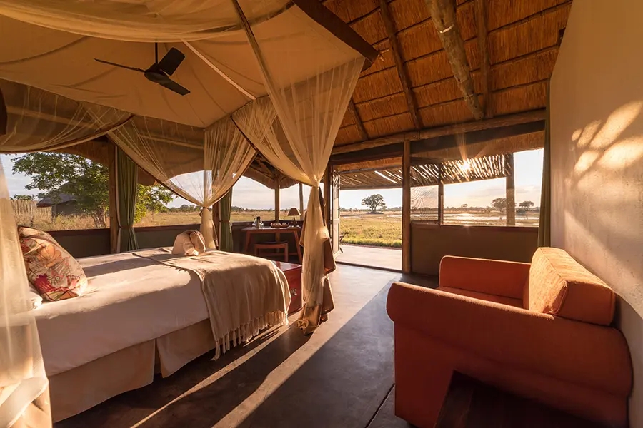Una espaciosa suite con cama de cuatro postes y grandes ventanales repartidos por la pared | Go2Africa