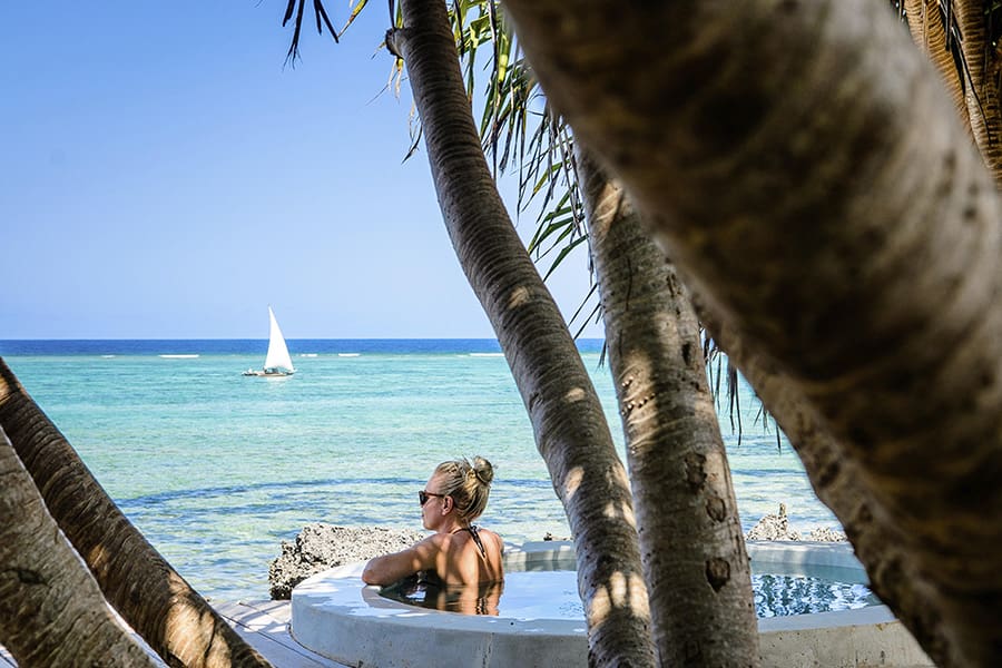 Woman relaxing in a plunge pools as she looks out into the ocean at Matemwe Lodge in Zanzibar, Tanzania.