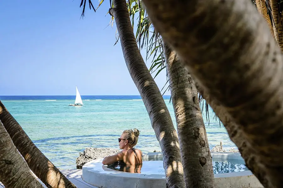 Una mujer se relaja en una piscina mientras mira al océano en el Matemwe Lodge de Zanzíbar, Tanzania.