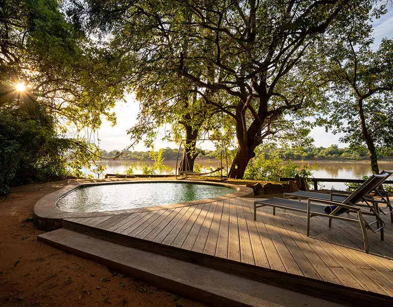 The swimming pool deck overlooks the river. 