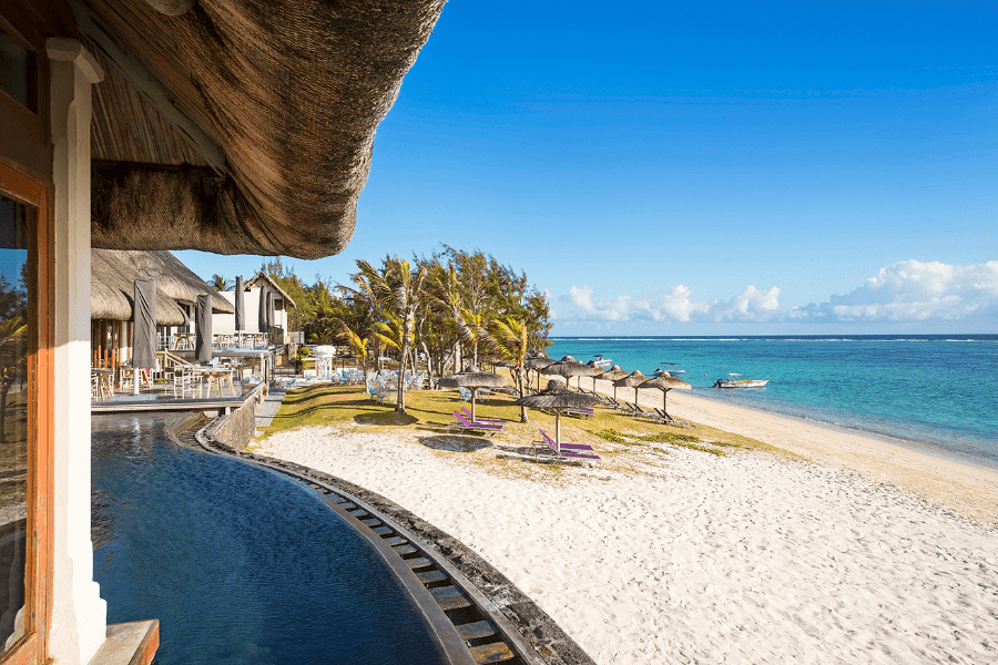 Beach with palapas and palm trees with a small part of C Mauritius pool pictured | Go2Africa