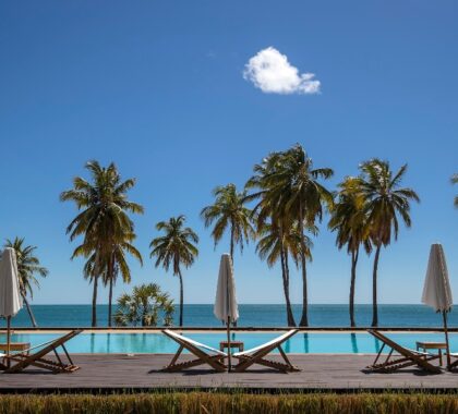Palm trees, poolside chairs, and umbrellas at Anjajavy le Lodge in Madagascar | Go2Africa