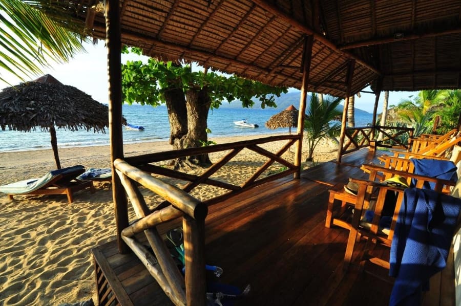 Views from a balcony at Antoremba Beach Lodge of the beach, loungers, and trees | Go2Africa