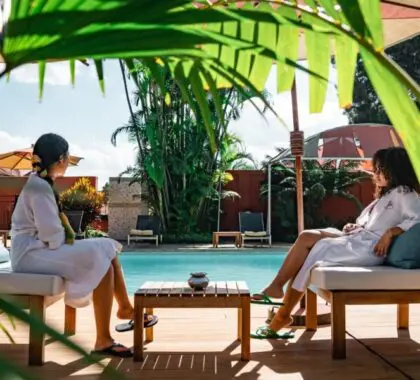 Two women sitting by a pool under trees in Madagascar | Go2Africa