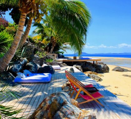 Several seating options on a wooden deck on a white sandy beach in Madagascar | Go2Africa