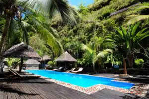 Thatched palapas and a pristine pool surrounded by gardens.