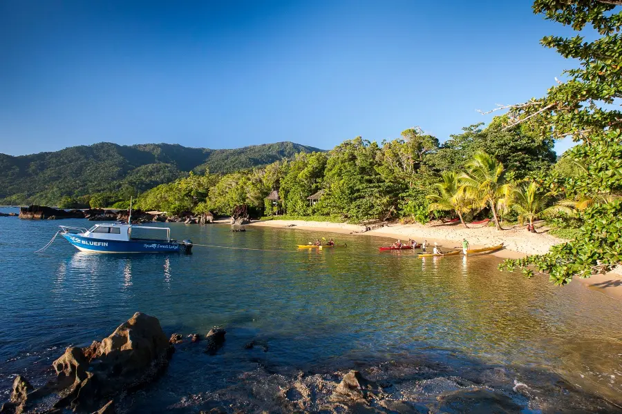 A boat pictured near a long stretch of beach with forest found behind at Masoala Lodge in Madagascar | Go2Africa