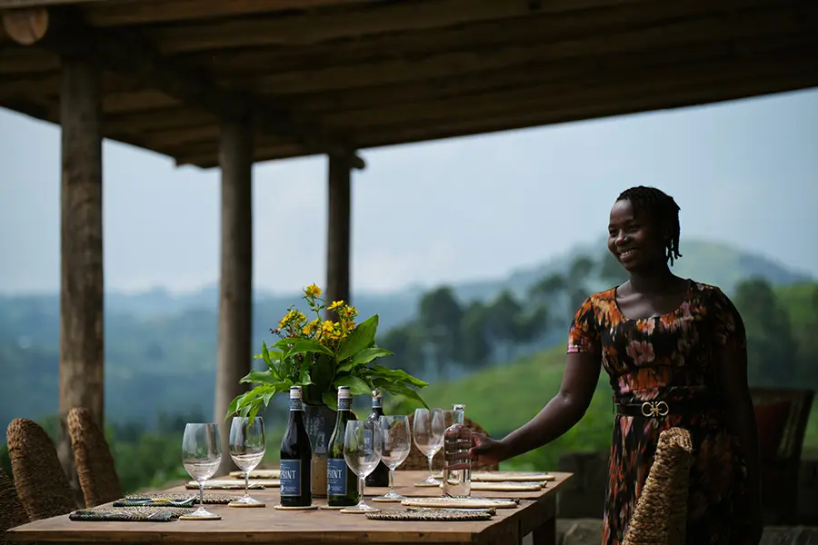 A staff member assembles the dining table for guests to enjoy lunch overlooking the park