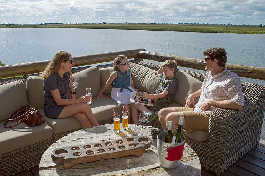 A family of two parents and their two children enjoy some quality time on the deck overlooking the Chobe River