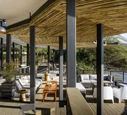 La zona principal del lodge Sanctuary Olonana incluye una amplia terraza y un salón con vistas al río.