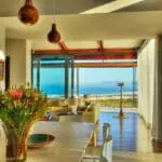 Las puertas correderas de cristal inundan el espacio de luz natural, creando un ambiente confortable perfecto para disfrutar del desayuno.