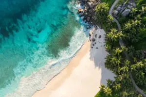 Enjoy a stroll along the tranquil coastline of Anse Intendance.