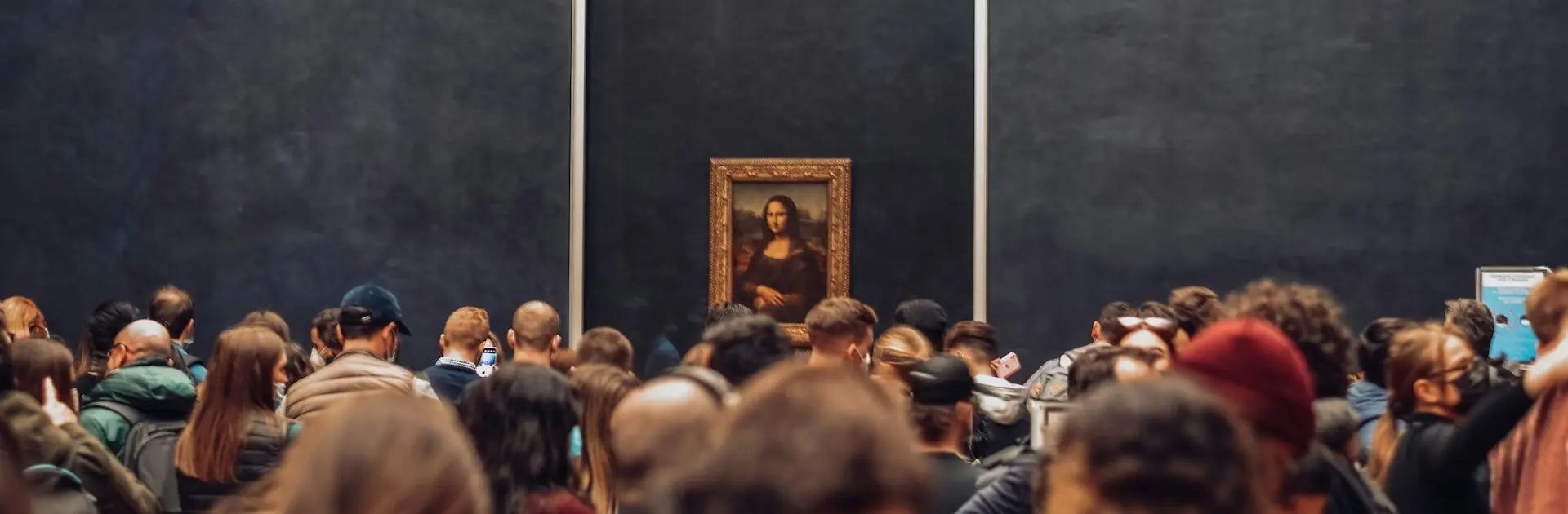 a crowd of people standing in front of a painting