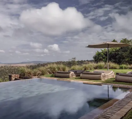The swimming pool area is furnished with loungers and umbrellas. 