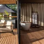 A free-standing bathtub next to a mesh window for lake views while you soak. 