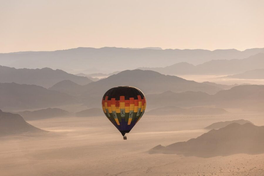 A hot air balloon sails above the Sossusvlei plains