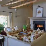 Acurrúquese junto a la chimenea con una copa de vino en la mano.