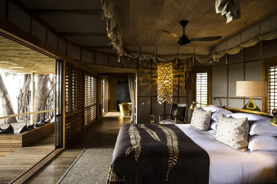 Elegant suite interior at Mombo Camp with natural textures and sweeping views over the Okavango Delta floodplain | Go2Africa