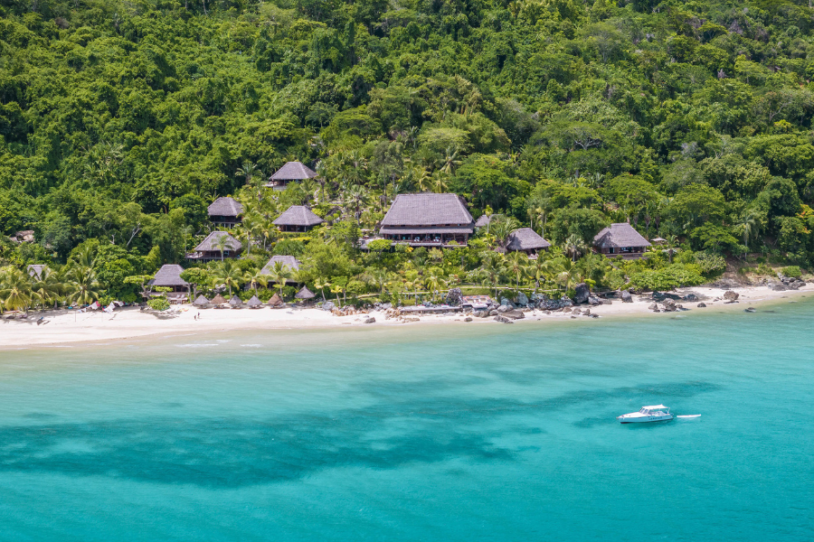 Aerial view of a beachfront lodge surrounded by lush rainforest and turquoise ocean | Go2Africa