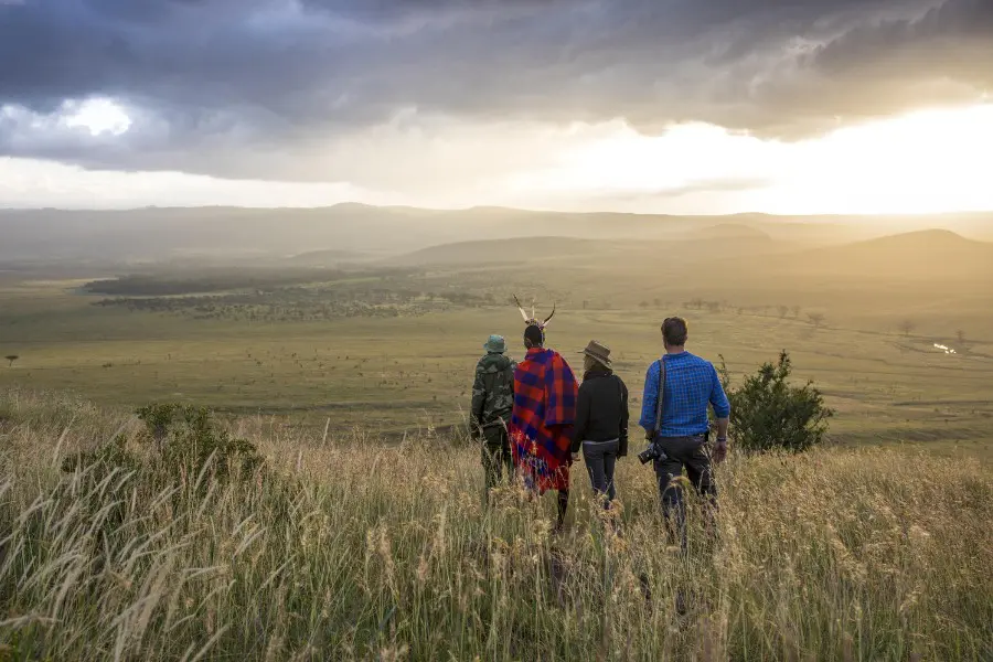 Maasai guide walking with guests in Lewa Conservancy in Kenya | Go2Africa