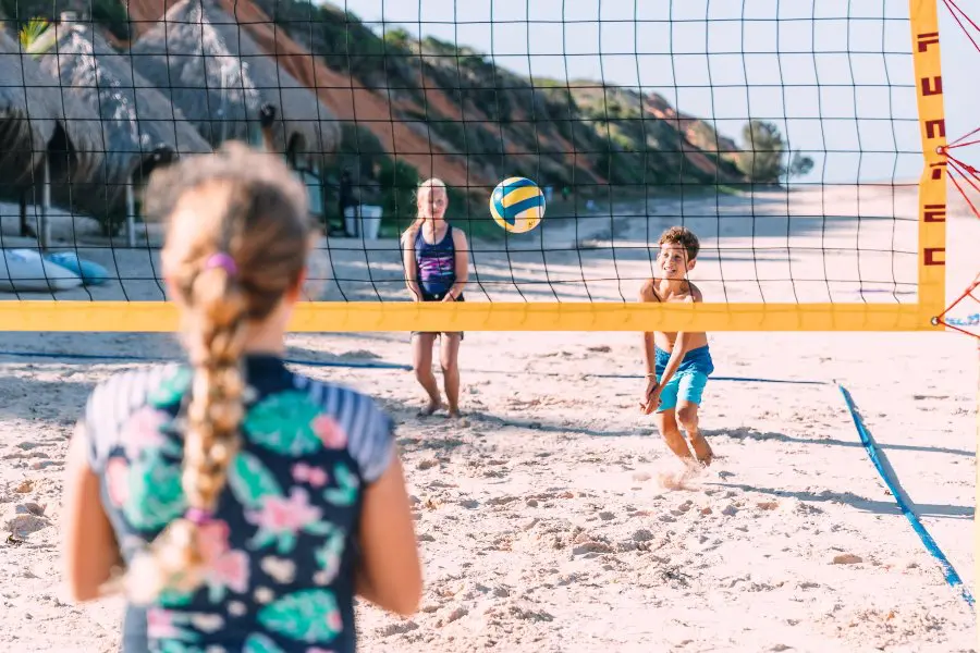 Family playing beach volleyball on the sand in Mozambique | Go2Africa